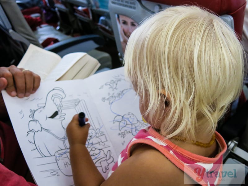 toddler on plane with coloring book