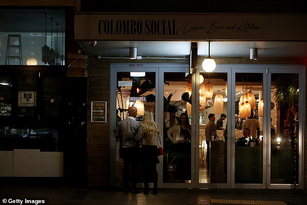 Couples are seen queuing outside Colombo Social in Sydney on Friday night (pictured) as residents hit the town with coronavirus restrictions eased