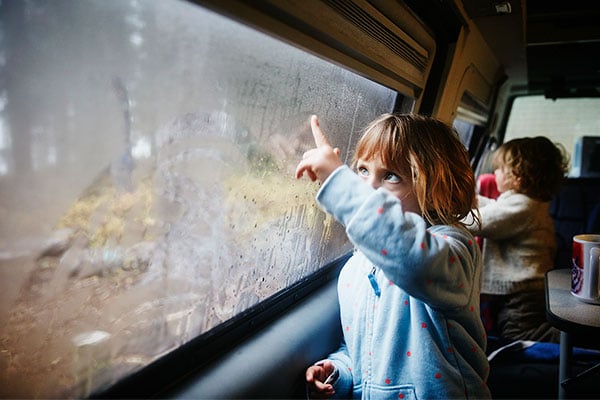Children drawing on windows inside camper van