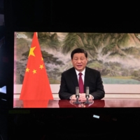 Chinese President Xi Jinping speaks remotely at the opening of the WEF Davos Agenda virtual sessions at the WEF's headquaters in Cologny near Geneva on Monday. China's efforts to repatriate accused criminals has netted nearly 10,000 people since Xi launched the initiative over seven years ago. | AFP-JIJI