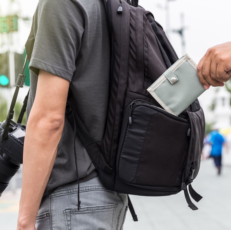 Man with backpack being pickpocketed on vacation