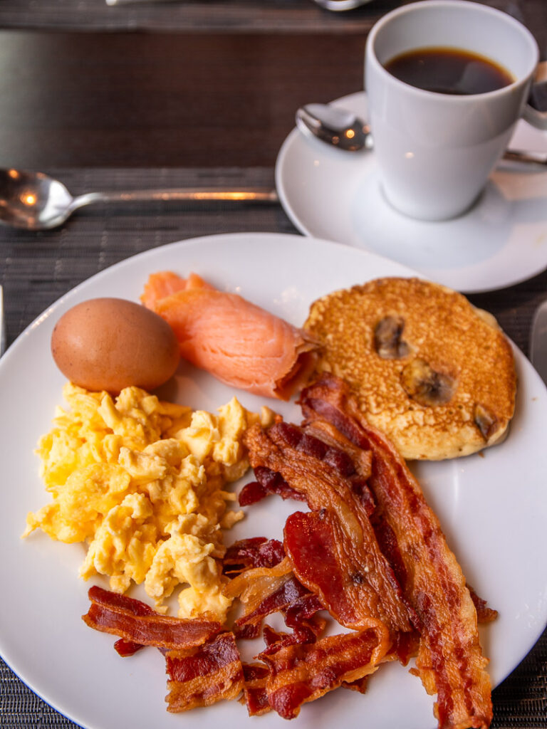 Bacon and eggs with coffee on a plate