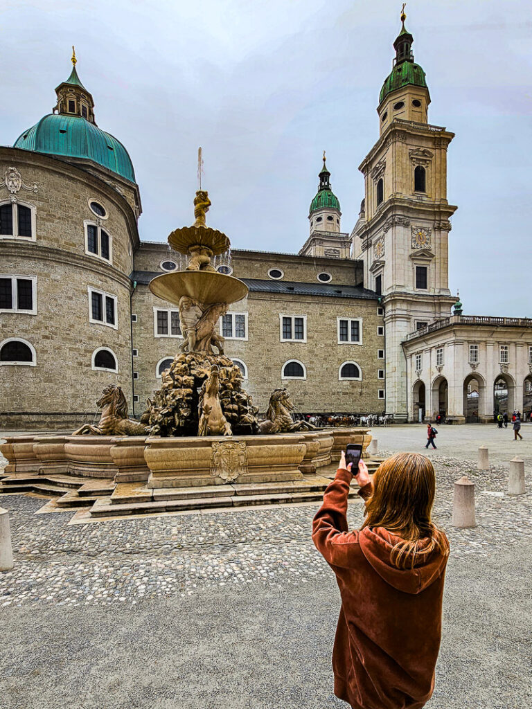 Girl taking photo of a fountain