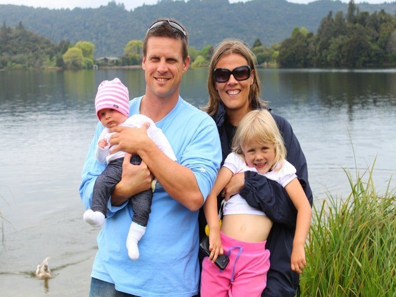 family posing by lake